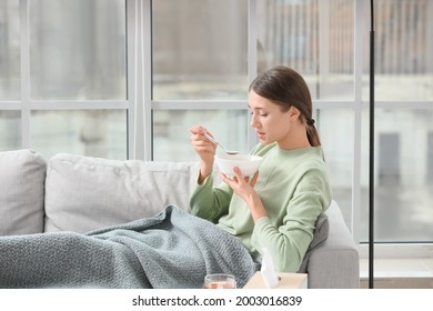 Sick Young Woman Eating Chicken Soup At Home