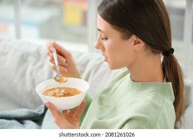 Sick Young Woman Eating Chicken Soup At Home