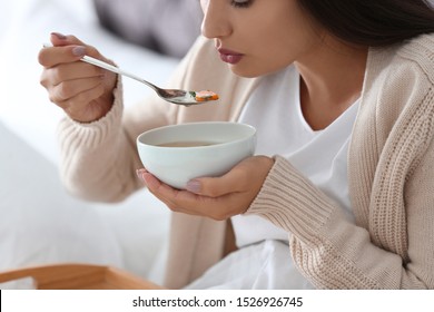 Sick Young Woman Eating Soup To Cure Flu At Home