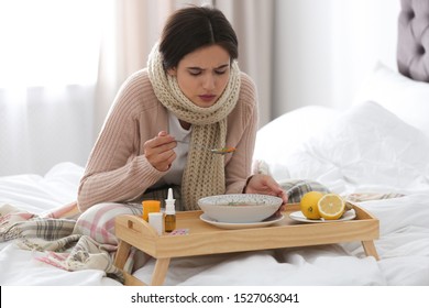 Sick Young Woman Eating Soup To Cure Flu In Bed At Home