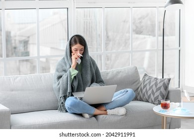 Sick Young Woman With Laptop Working At Home