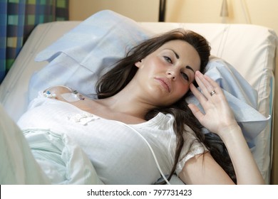 Sick young woman laying in hospital bed with Central Venous Catheter (CVC) being administered fluids and Parenteral Nutrition (PN)Model Release: Yes. Property release: No. - Shutterstock ID 797731423
