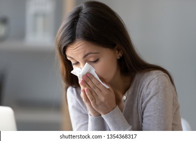 Sick Young Woman Sitting Indoors Holding Tissue Handkerchief Blowing Running Nose Feels Unwell Unhealthy, Girl Having Symptoms Of Chronic Sinusitis Disease, Seasonal Allergy Or Cold Fever Flu Concept