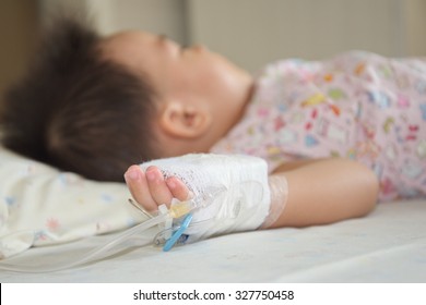 Sicked Kid Sleeping In Hospita,Illness Little Asian (thai) Baby Asleep On A Sickbed, Saline Intravenous On Hand