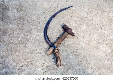 Sickle and hammer (serp i molot). Communist symbol. Farm and worker tools on the concrete surface. - Shutterstock ID 620837000