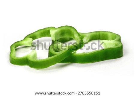 Side angle shot of two fresh green bell pepper rings isolated on clean white backdrop.