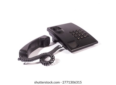 Side angle view of a black office desk phone with its handset off the base, isolated on a white background. Concept of communication and customer service. 