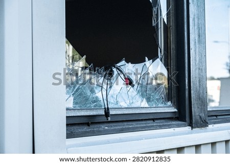 Side angle view of broken office window with glass shards