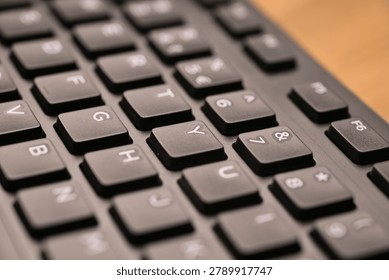 Side Angled Top View Macro Close-Up Black Computer Keyboard Highlighting Y Key with Soft Blurred Tech Backgrounds