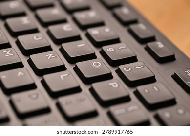 Side Angled Top View Macro Close-Up Black Computer Keyboard Highlighting O Key with Soft Blurred Tech Backgrounds