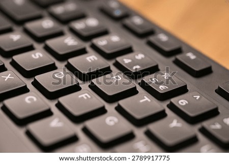 Side Angled Top View Macro Close-Up Black Computer Keyboard Highlighting R Key with Soft Blurred Tech Backgrounds