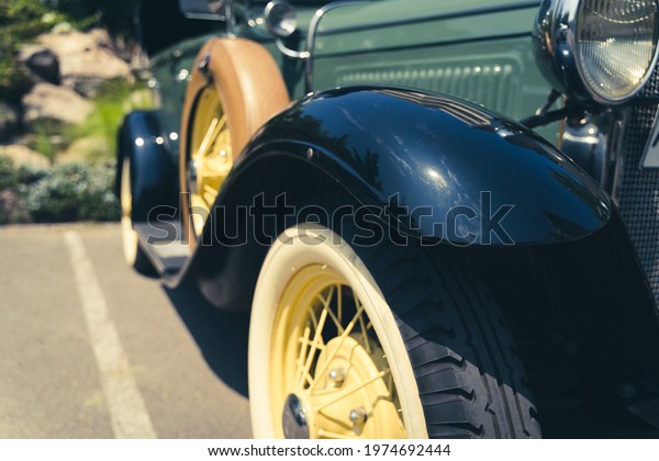 Side of antique car\
with spare wheel. Classic automobile parked outdoors on sunny day.\
Collectible concept
