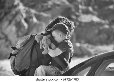 Side Black And White Photo Of Dad Hugging His Son. Boy Holding His Favorite Teddy Toy. Mountains Background. True Feelings