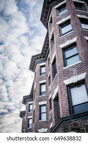 Side of building with bay windows and dramatic sky