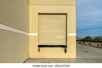 A Side Of Building Shipping And Receiving Roll Up Door At Industrial Factory Warehouse Area