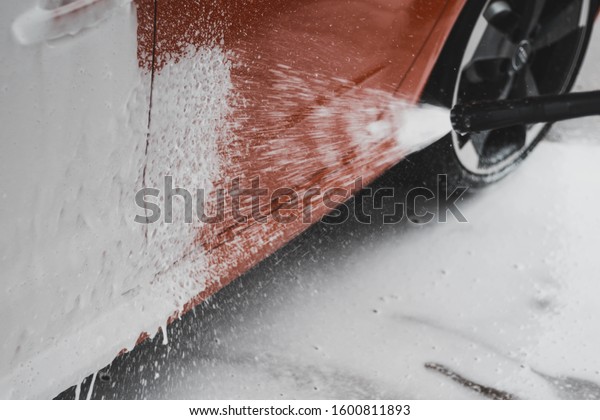 Side of a car\
covered with cleaning\
foam.