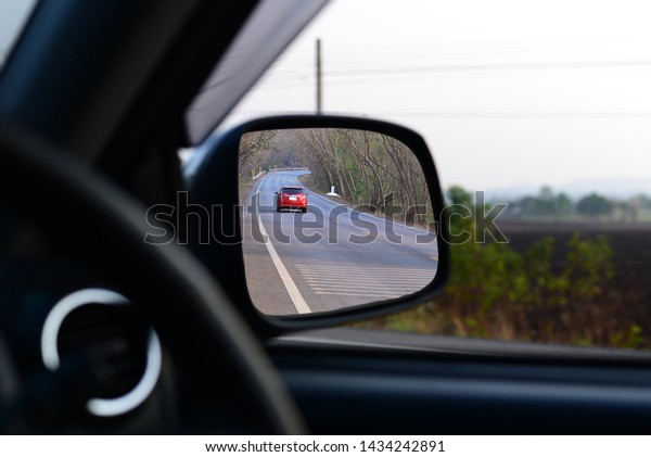 Side car mirror\
with image of road on the\
way.