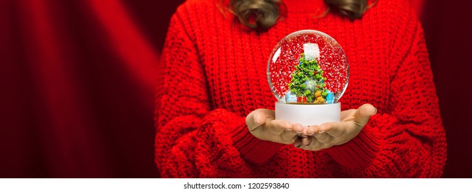 Side Close Up Portrait Of A Joyful Young Woman Holding A Snow Globe