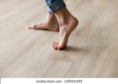 Side close up view of unrecognizable woman feet legs, barefoot girl standing indoors inside of modern home enjoy warm wooden heated floor, perfect groomed body part pedicure services spa salon concept - Shutterstock ID 1390231295