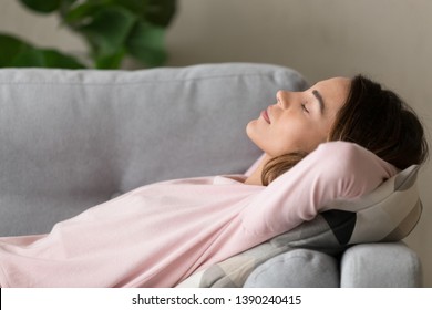 Side close up view young serene woman lying on comfy couch putting hands behind head closed her eyes sleeping or having day nap resting alone, lazy weekend at home refreshment and renew energy concept