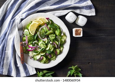 Side Dish - Low Fat Cucumber Salad Of Crunchy Sliced Cucumbers, Pickled Red Onions, Chopped Dill, Fresh Mint With Vinaigrette Garlic And Olive Oil Dressing On A White Plate, Copy Space