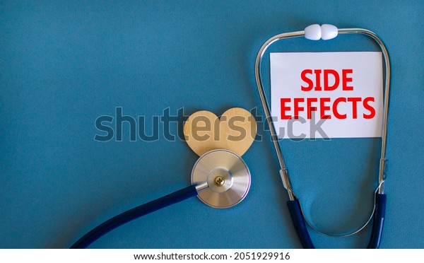 Side effects symbol. White card with words Side\
effects, beautiful blue background, wooden heart and stethoscope.\
Medical and side effects\
concept.