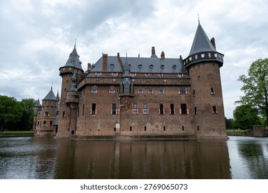Side elevation of De Haar Castle with brick towers and moat water, photographed at Haarzuilens, Utrecht, Netherlands.