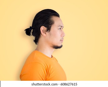 Side Face Of Asian Artist Man Isolated On Yellow Background.