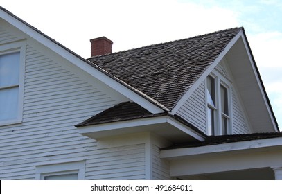 Side Gable And Front Reverse Gable Create A Roof Valley On Old White Painted House With Clapboard Siding And Cedar Shake Shingles 