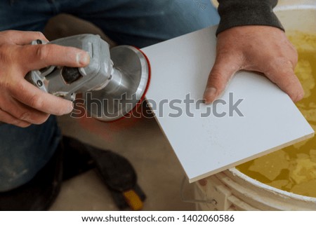 Side grinder working on paving tile on building with electric grinder