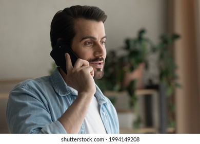 Side Head Shot View Happy Young Handsome Man Holding Phone Call Conversation, Communicating Distantly With Friends Or Family, Talking With Operator, Ordering Goods Or Services Distantly At Home.