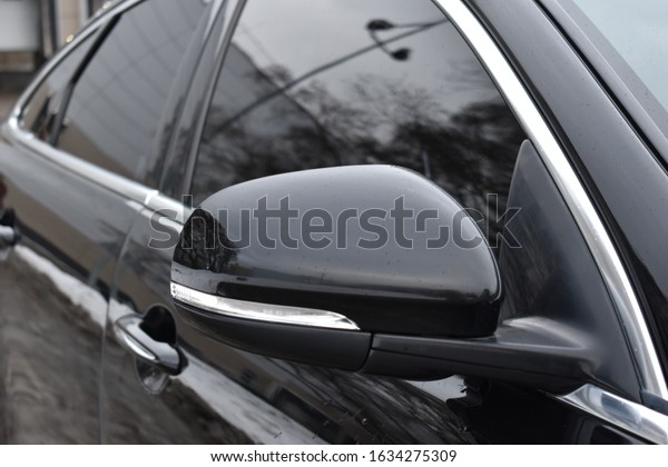 The side mirror of the car. Black expensive car.\
The rear view mirror.