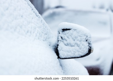 The side mirror of a car covered in snow. Selective focus copy space