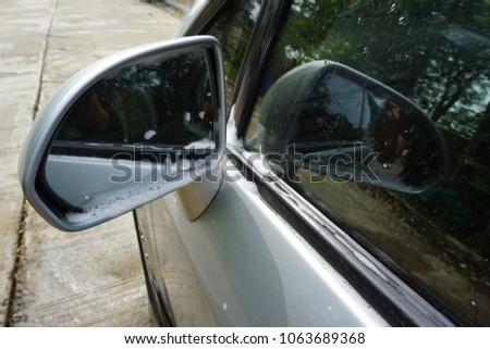 Similar – Eine Frau in einer mit großem Ausschnitt sitzt in ihrem Auto auf der rechten Seite vorne und schminkt sich, legt Schmuck an. Man kann sie durch die Reflexion in der Windschutzscheibe nicht erkennen