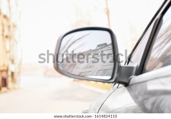 Side mirror of modern\
car on city street