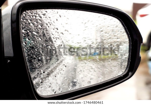 a side mirror of\
a modern car in raindrops