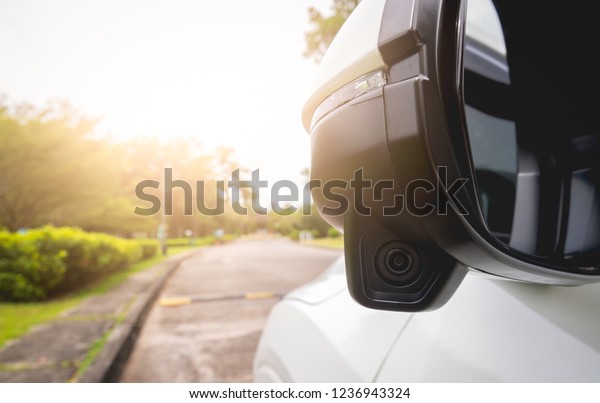 Side mirror on car with side camera to see\
the car overtaking in an invisible angle Helps reduce vacuum\
accident Transportation and safety\
concept