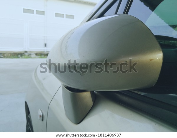 Side mirror on the left side of the car that has\
discolored marks.