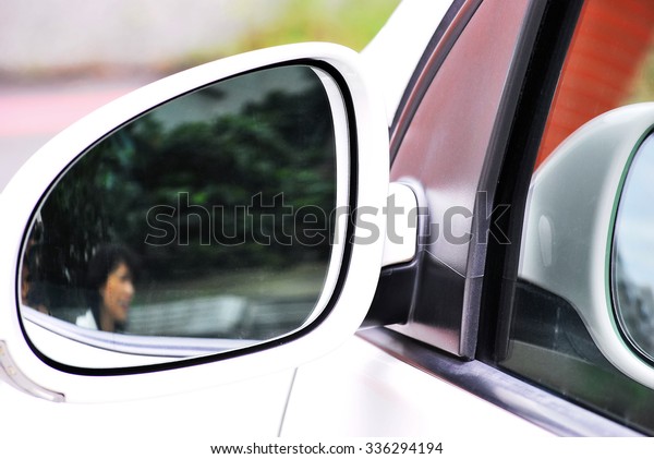 Side mirror and\
reflection of a passing\
woman