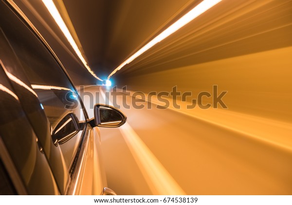 side mirror view of car driving in the tunnel with\
motion blur