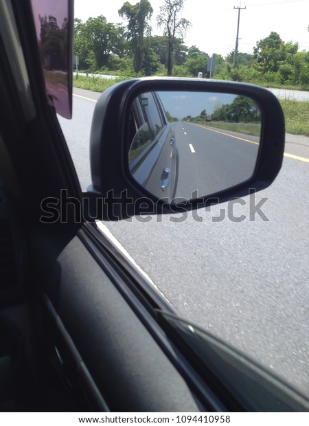 Side mirrors, cars and cars are running on the\
roads in Thailand.