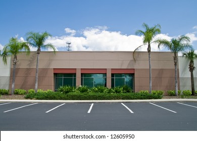 Side Of Office Building With Parking Spaces And Palm Trees