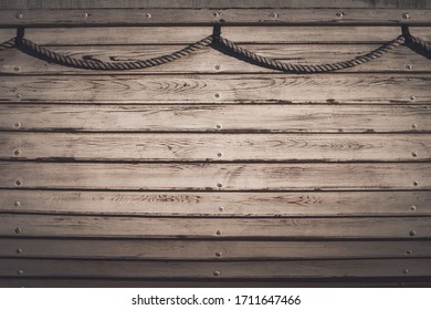 The Side Of An Old Wooden Boat With Ship Rope. Marine Wood Texture Background With Copy Space.