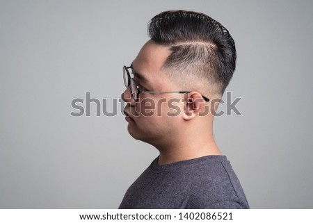 Side part : a hairstyle for men with thin hair and round face / a portrait of a head of an adorable man on light gray background with copy space