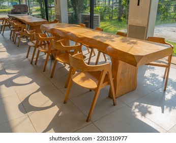 A Side Perspective Of Two Long Wooden Dining Table With Matching Chairs.