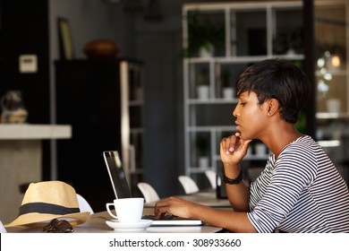 Side Portrait Of An African American Woman Using Laptop At Cafe Restaurant