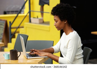 Side Portrait Of An Attractive Young Woman Using Laptop Outside