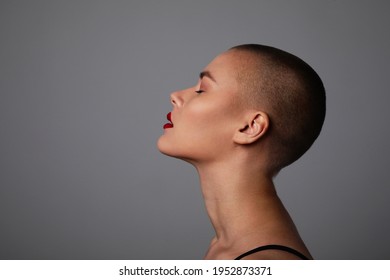 Side Portrait Of A Beautiful Bald Woman. Studio Shot.