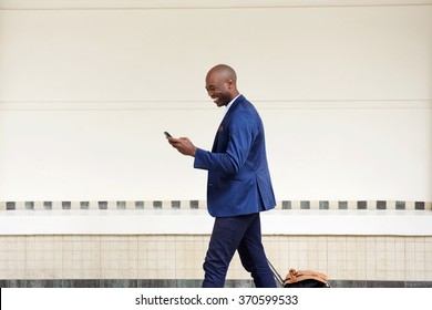 Side Portrait Of Business Man Traveling With A Bag And Mobile Phone 