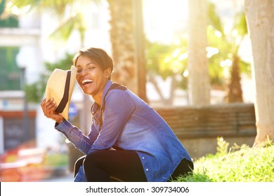 Side portrait of a carefree young woman laughing outside